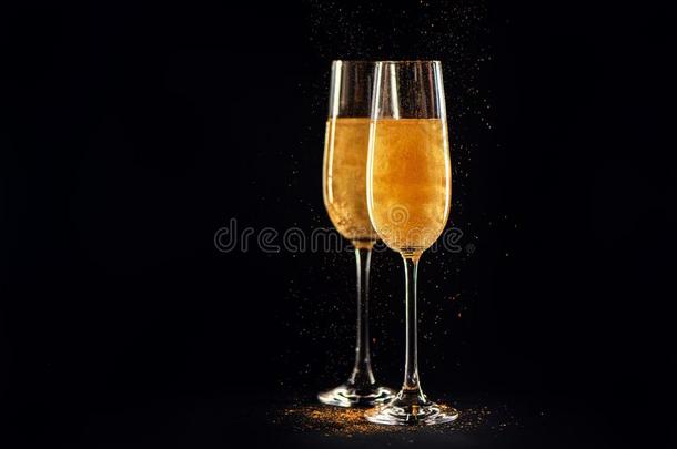 两个眼镜关于香槟酒和<strong>金色</strong>的闪烁向黑的背景