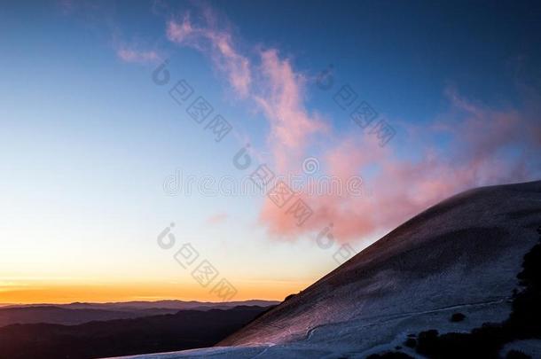 山顶大量的在旁边雪边界紫色的云一日落.