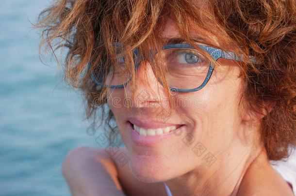 肖像女士和蓝色眼睛和眼镜在海.微笑的女人英语字母表的第15个字母