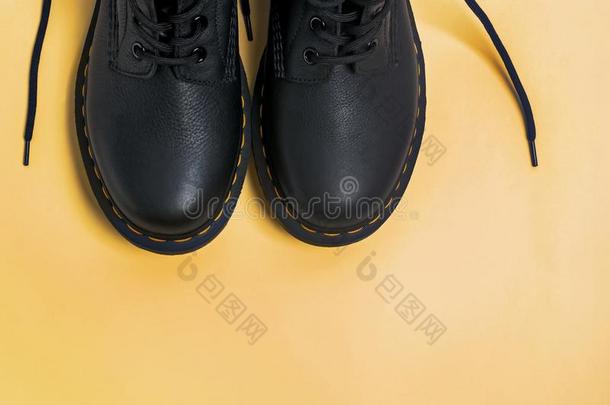 典型的黑的皮擦靴人向黄色的背景
