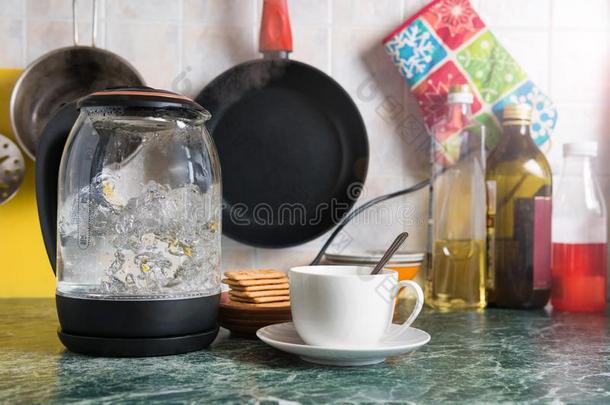 电的透明的玻璃茶壶沸腾采用指已提到的人厨房