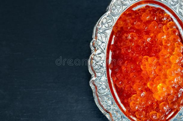红色的鱼子酱采用银碗向黑的背景