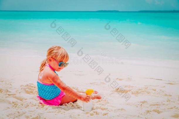 太阳保护-小的女孩和防晒霜向海滩