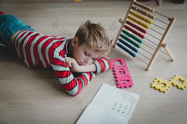 小的男孩疲倦的和强调关于做家庭作业