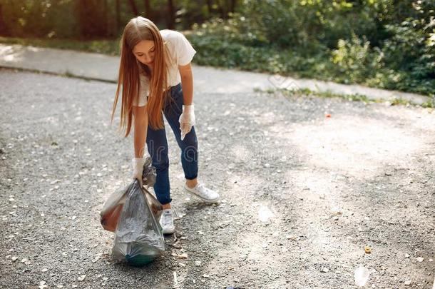 女孩收集垃圾采用垃圾袋采用公园