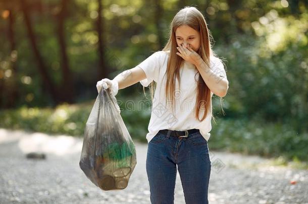 女孩收集垃圾采用垃圾袋采用公园
