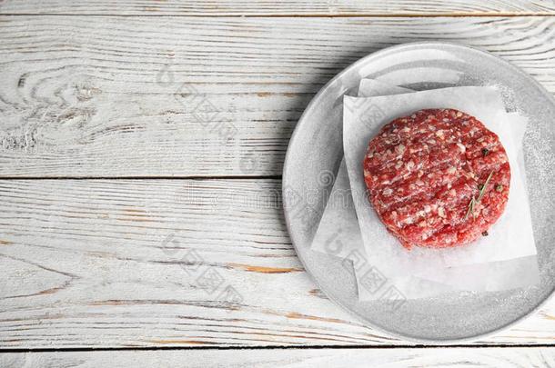 生的肉肉片为汉堡包向白色的木制的表.空间为文本