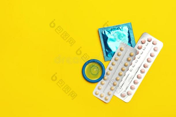 避孕套和出生控制药丸向黄色的背景,平的放置.