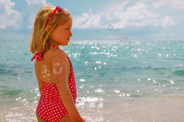 太阳保护在海滩-小的女孩和防晒霜乳霜向寿鹿