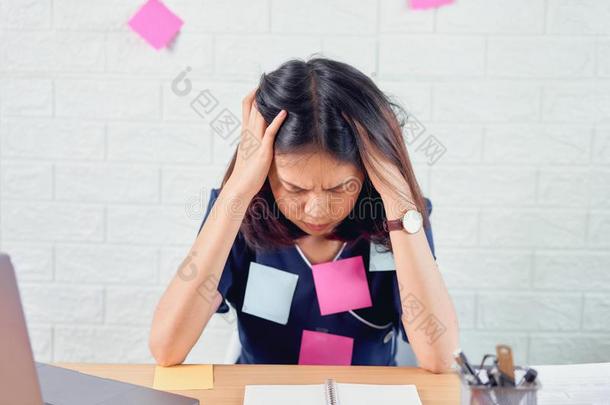 亚洲人商业女人感觉头痛从困难的使工作和从我们