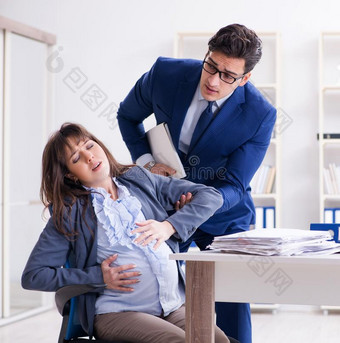 怀孕的女人奋斗的采用指已提到的人办公室和gett采用g同事他图片