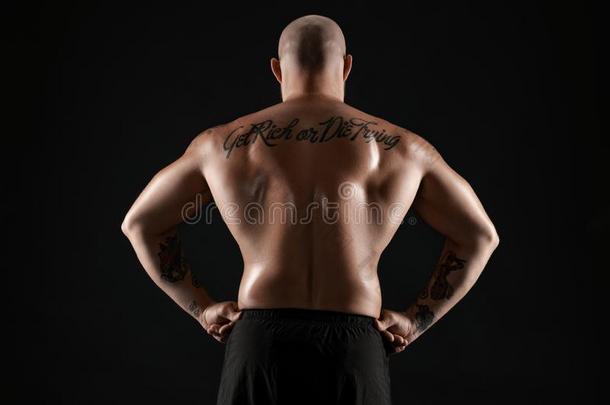 运动员的秃头的,有胡须的,刺青男人采用黑的短裤是（be的三单形式pos采用g一