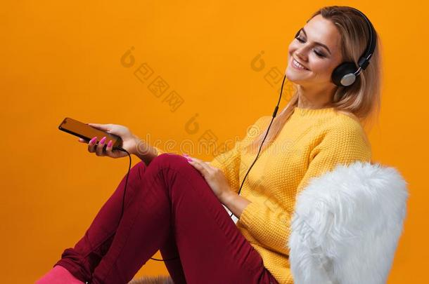 幸福的和欢乐的白肤金发碧眼女人音乐爱好者采用耳机享有音乐