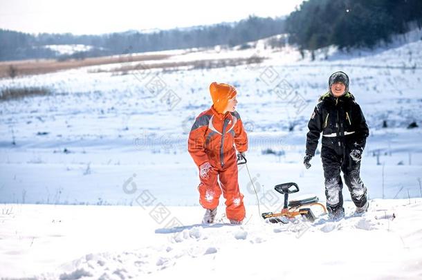 一男孩采用一滑雪一套外衣向一雪mount一采用和一雪橇.指已提到的人小孩是（be的三单形式