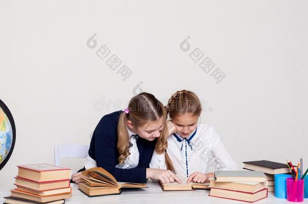 两个女学生女儿和书在指已提到的人学校书桌