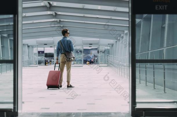 年幼的男人和行李离开机场股份照片