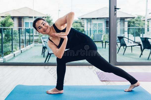 年幼的女人做扭成一束使摆姿势瑜伽