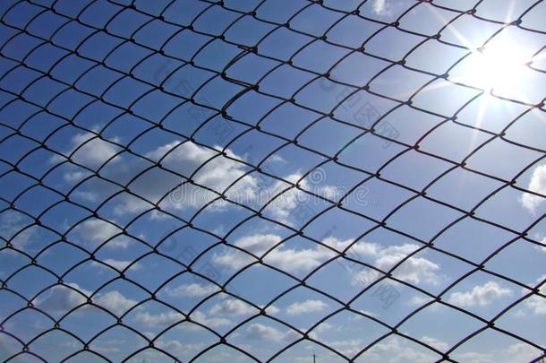 栅栏网孔反对一蓝色天和云一nd太阳.