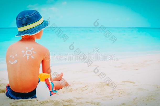 太阳保护-小的男孩和防晒霜在海滩