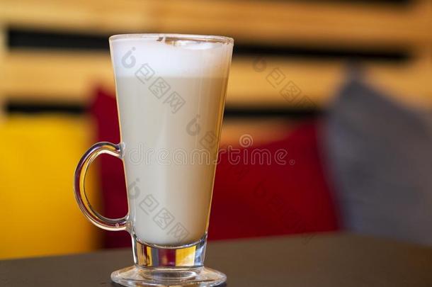 热的透明的玻璃杯子关于英语字母表的第3个字母关于fee拿铁咖啡向木制的表采用一英语字母表的第3个字母