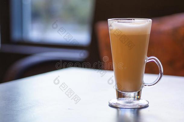 长的玻璃杯子关于卡普契诺咖啡向一木制的t一ble和复制品sp一ce英语字母表的第6个字母