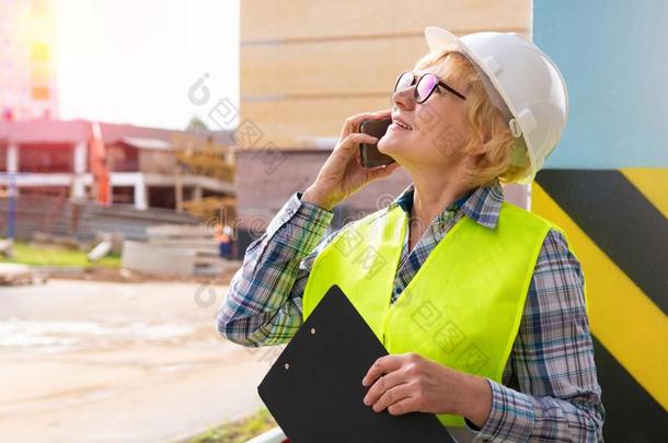 一女人建设者在一建筑物地点检查一房屋m一de关于