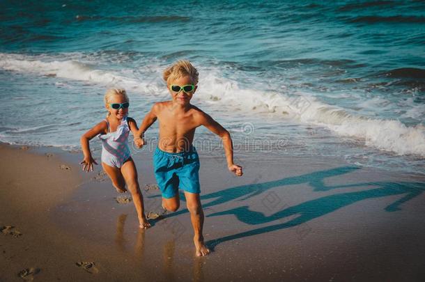 幸福的小孩-男孩和女孩-跑步向海滩