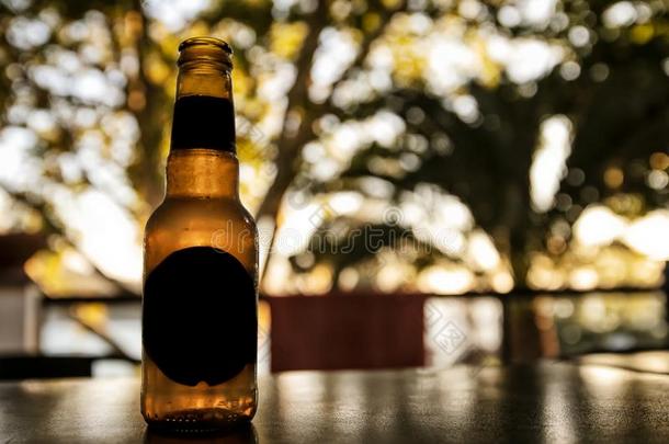 啤酒瓶子向指已提到的人表和变模糊背景.日落光