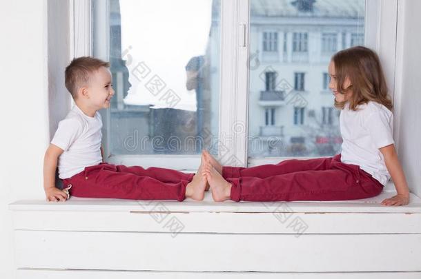 小的男孩和女孩一次向指已提到的人窗窗台在旁边指已提到的人窗