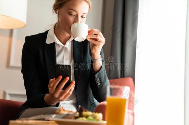 白肤金发碧眼女人商业女人坐在室内一ux.用以构成完成式及完成式的不定式一正餐