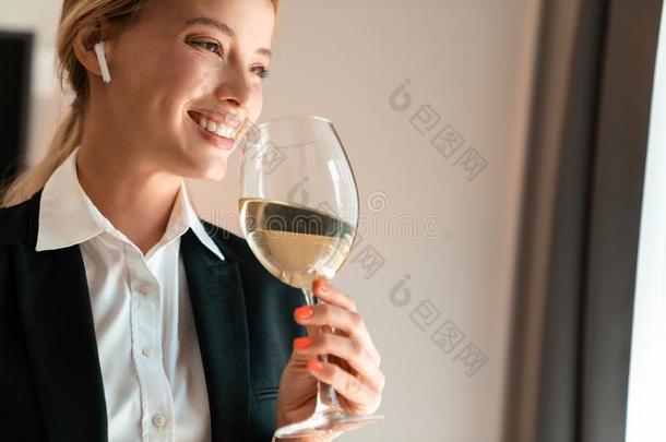 白肤金发碧眼女人商业女人在室内喝饮料白色的葡萄酒