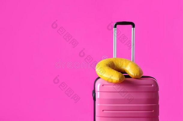 手提箱和黄色的旅行枕头向粉红色的,空间为文本