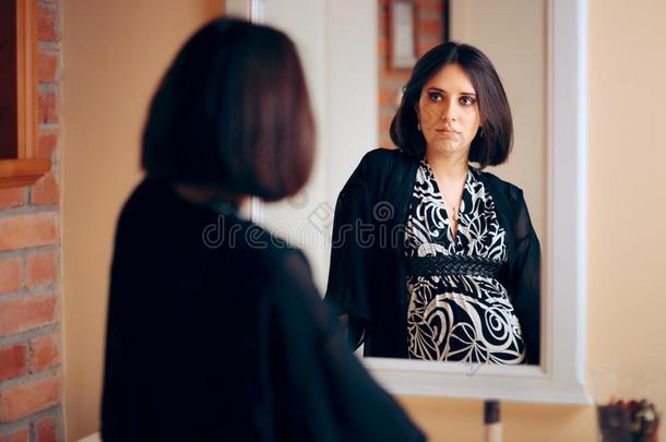 反省的怀孕的女人分析她自己采用一镜子