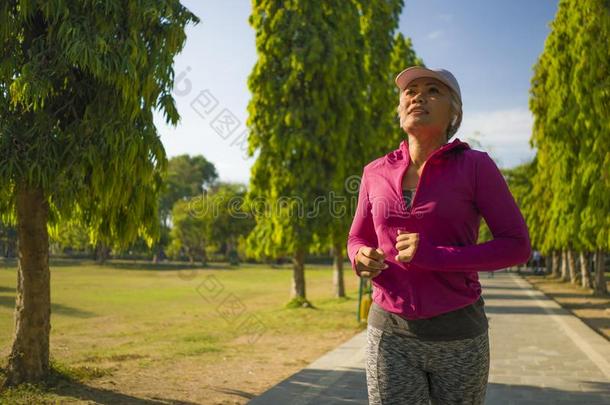 有魅力的中部老年的女人跑步幸福的在城市公园.很漂亮