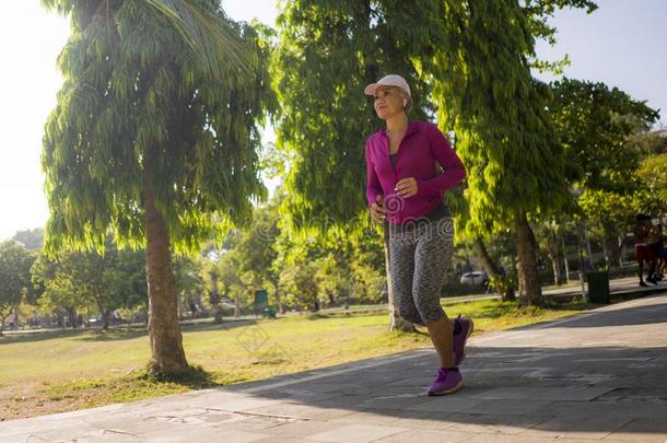 有魅力的中部老年的女人跑步幸福的在城市公园.很漂亮
