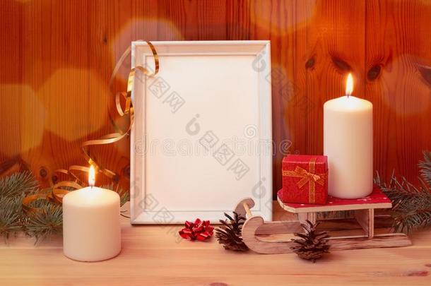 白色的照片框架,圣诞节蜡烛和赠品向木制的表.英语字母表的第22个字母