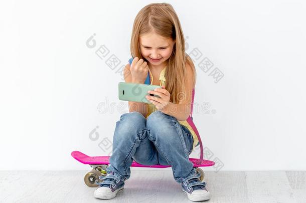 小的女孩观察电话,一次向溜冰