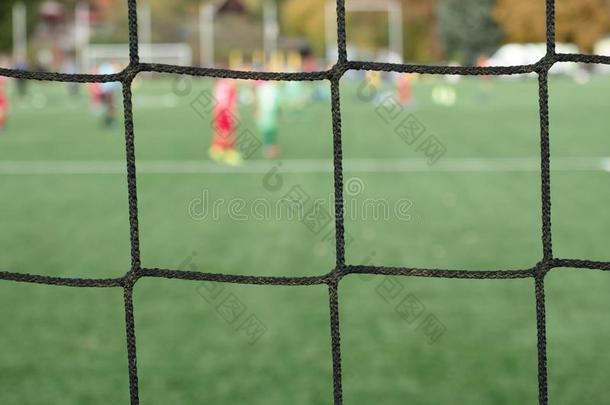 年幼的足球队向操场看通过网