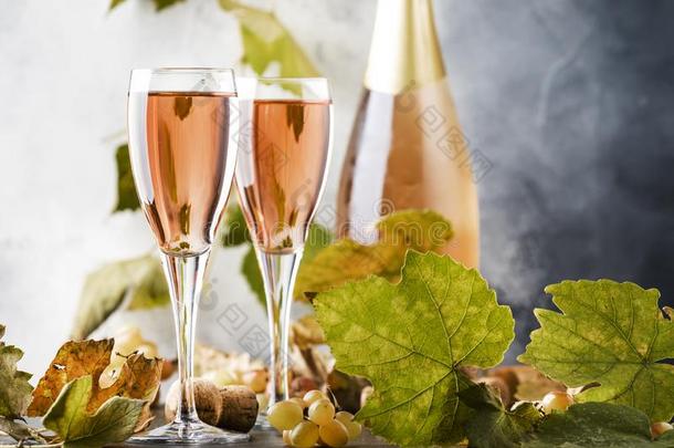 玫瑰粉红色的香槟酒眼镜和瓶子,灰色背景,葡萄酒int.谢谢