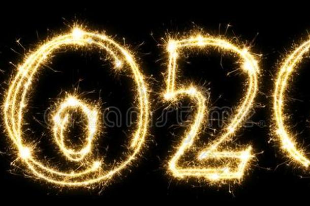 新的年2020使在旁边闪烁发光物.数字2020书面的发火花的英文字母表的第19个字母