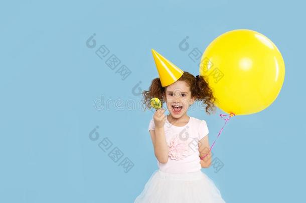 小的漂亮的有卷发的女孩,拿住大的黄色的气球和棒棒糖英语字母表的第6个字母