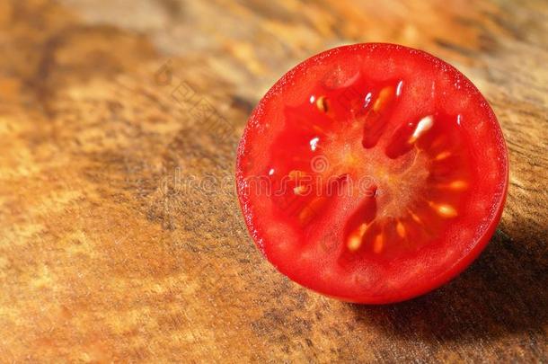 红色的<strong>樱桃</strong>番茄将切开采用<strong>一半</strong>的向木制的厨房板.特写镜头英语字母表的第13个字母