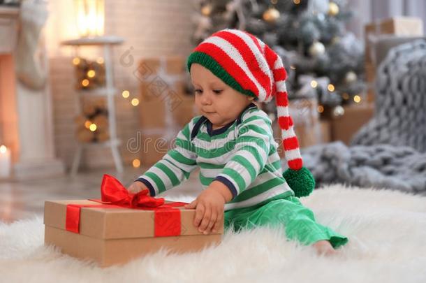 小的婴儿和<strong>小精灵帽子</strong>和圣诞节赠品向地面