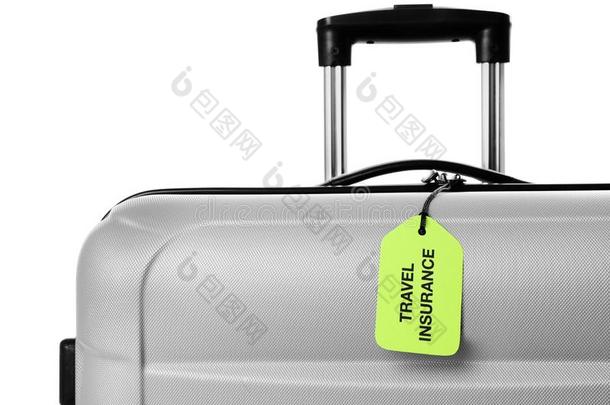 灰色的手提箱和旅行保险标签向白色的,特写镜头