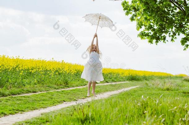 美丽的亚麻色的女孩使摆姿势和白色的遮阳伞雨伞