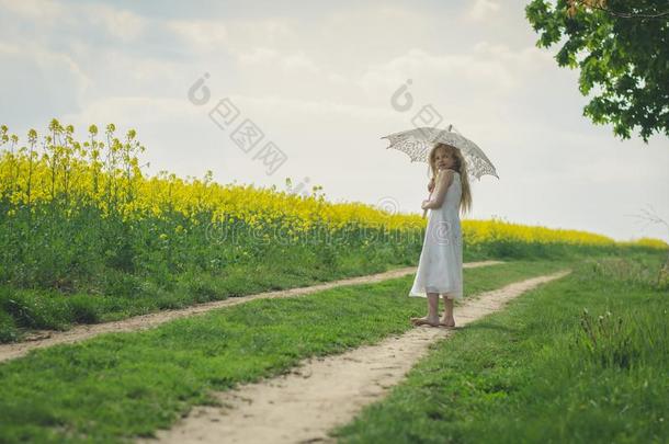 美丽的亚麻色的女孩使摆姿势和白色的遮阳伞雨伞