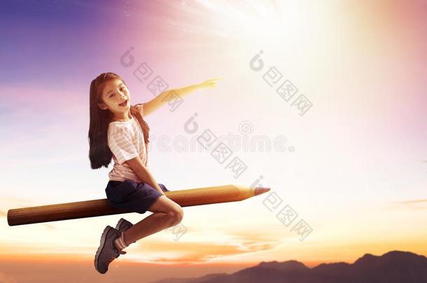 幸福的小的女孩向铅笔和飞行的采用指已提到的人天