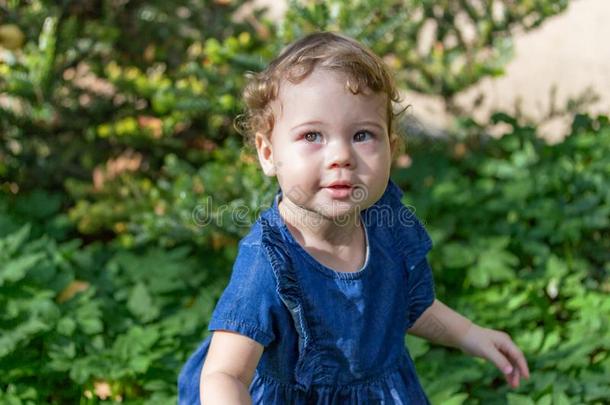 美丽的小的女孩采用一蓝色斜纹粗棉布衣服和一绺鬈发w一lks采用