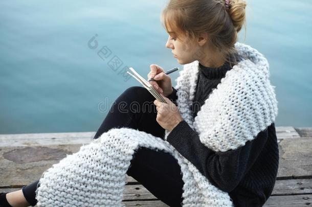 年幼的白肤金发碧眼女人女人使人疲乏的围巾一次向木制的码头文字