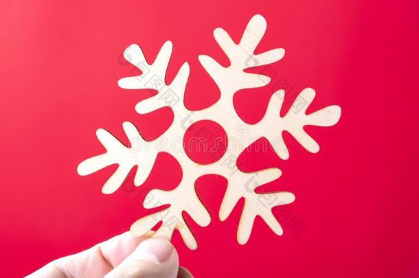 圣诞节装饰雪花采用手向一红色的b一ckground.胡里节